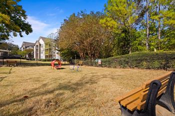 a park with a bench and a basketball hoop in the grass  at 150 Summit, Alabama, 35243